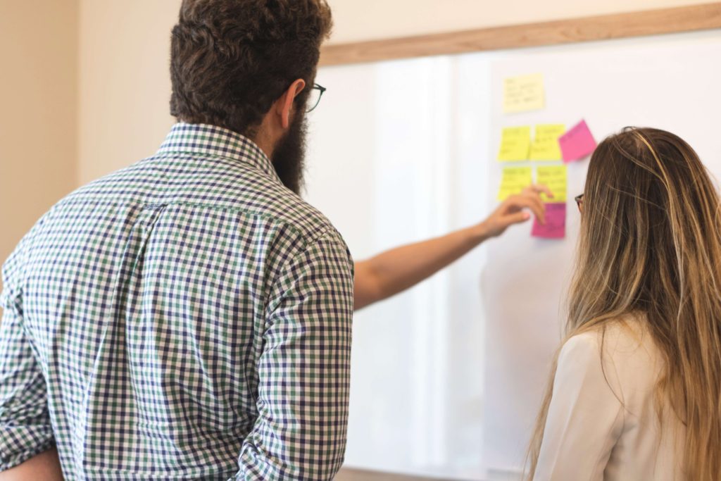 People standing in front of a table that has post-its on it.