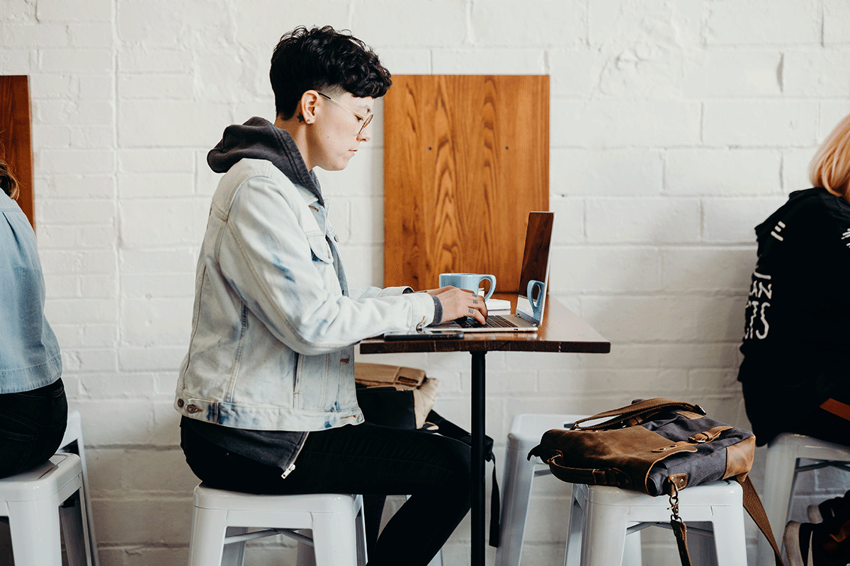 A lady at a coffee shop working on a computer